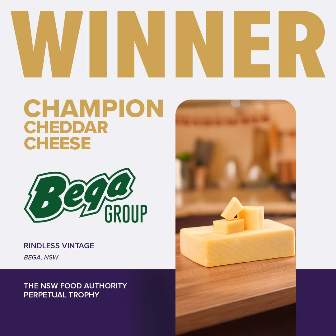 A block of Bega Group Rindless Vintage on a woodboard kitchen counter, awarded Champion Cheddar Cheese, NSW Food Authority Perpetual Trophy.